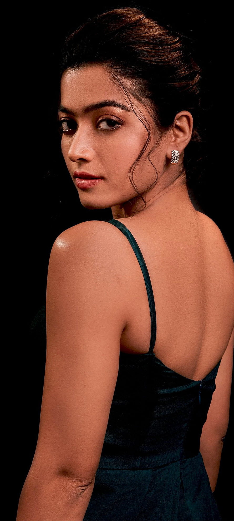 Portrait of a woman in a dark green dress looking back over her shoulder against a black background, Rashmika Mandanna , Telugu Actress, Indian actress, Black background, Hot actress, , People HD phone wallpaper
