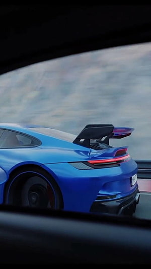 Rear Three-Quarter View of a Blue Porsche 992 GT3 with Prominent Rear Wing on a Track HD phone wallpaper