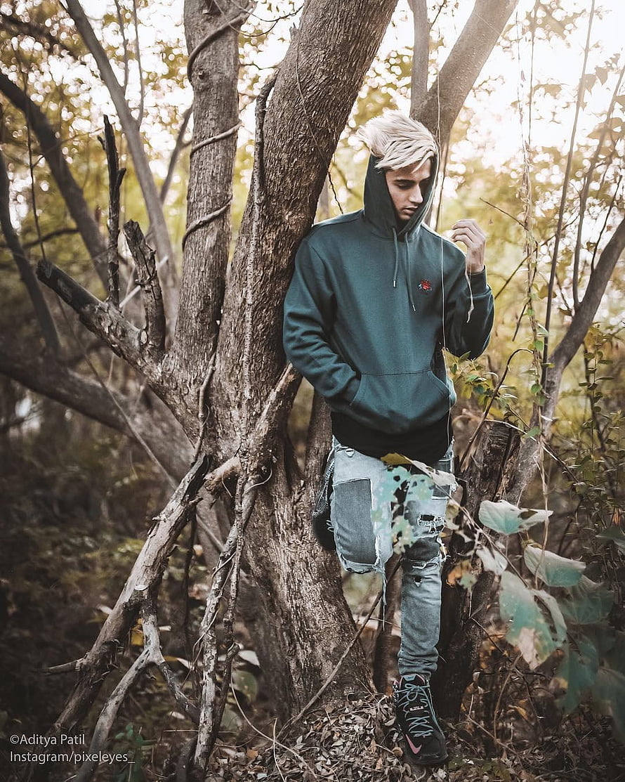 Danish Zehen in a forest setting wearing a dark hoodie and distressed jeans HD phone wallpaper