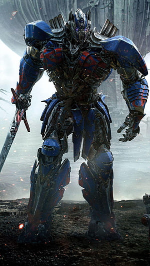 Optimus Prime from Transformers: The Last Knight Standing in a War-Torn Battlefield HD phone wallpaper
