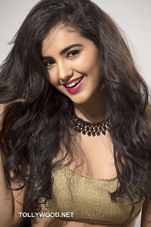 Malvika Sharma smiling portrait in gold top with long dark wavy hair and pink lipstick HD phone wallpaper