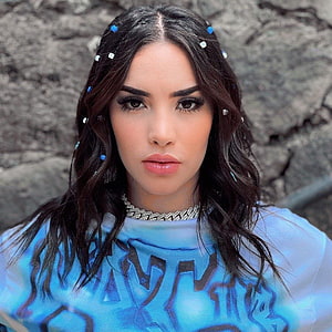 Kimberly Loaiza Portrait in Blue Patterned Top with Beaded Necklace and Hair Accessories HD phone wallpaper
