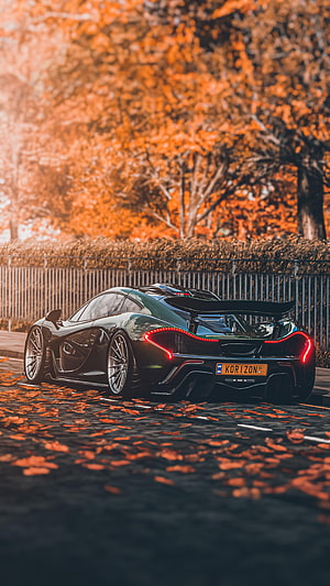 McLaren P1 Rear View on Autumn Street with Falling Leaves and Warm Golden Light HD phone wallpaper