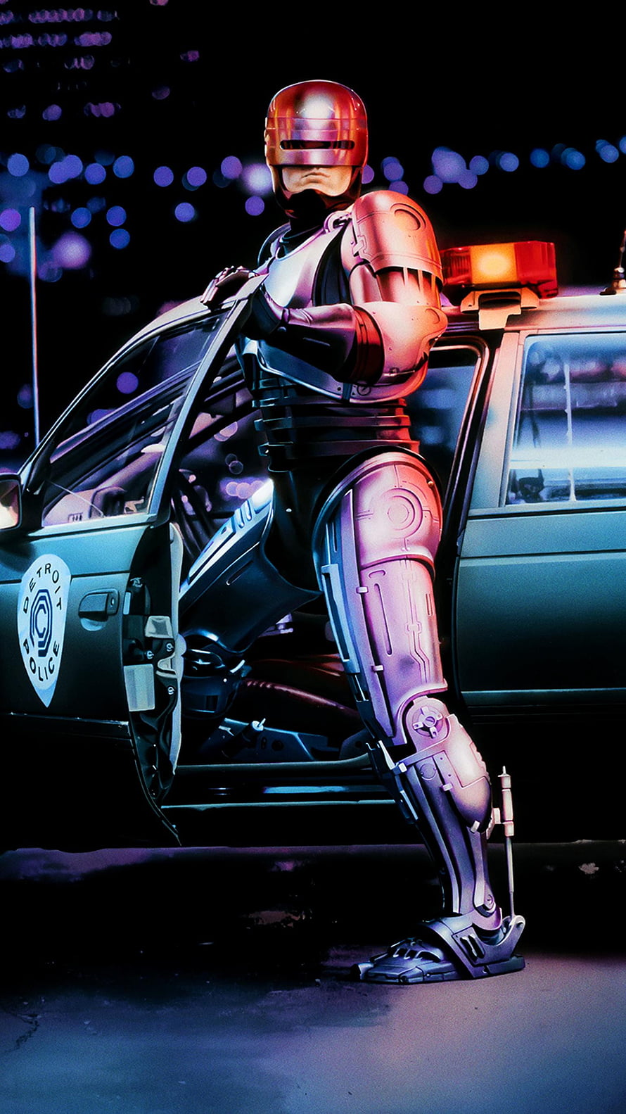 RoboCop Standing Beside a Detroit Police Cruiser in a Neon-Lit Night Scene HD phone wallpaper