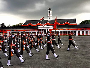 Indian Army soldiers marching in formation at the historic Red Fort in Delhi under a dramatic cloudy sky HD wallpaper