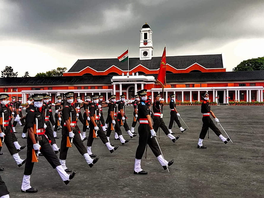 Indian Army soldiers marching in formation at the historic Red Fort in Delhi under a dramatic cloudy sky HD wallpaper