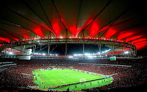 Maracana Stadium Interior With Red Lighting And Full Crowd During Night Football Match HD wallpaper