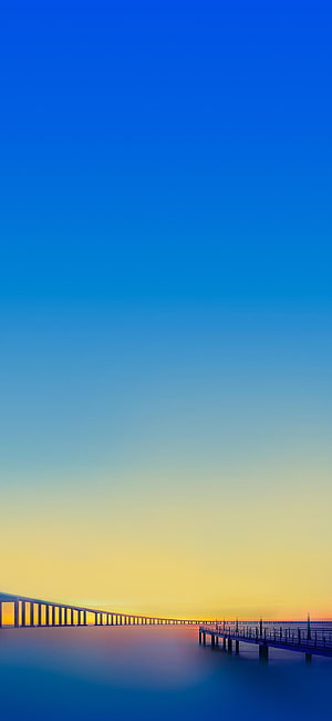 Serene Coastal Sunset with Long Bridge and Pier Silhouette Against Gradient Sky HD phone wallpaper