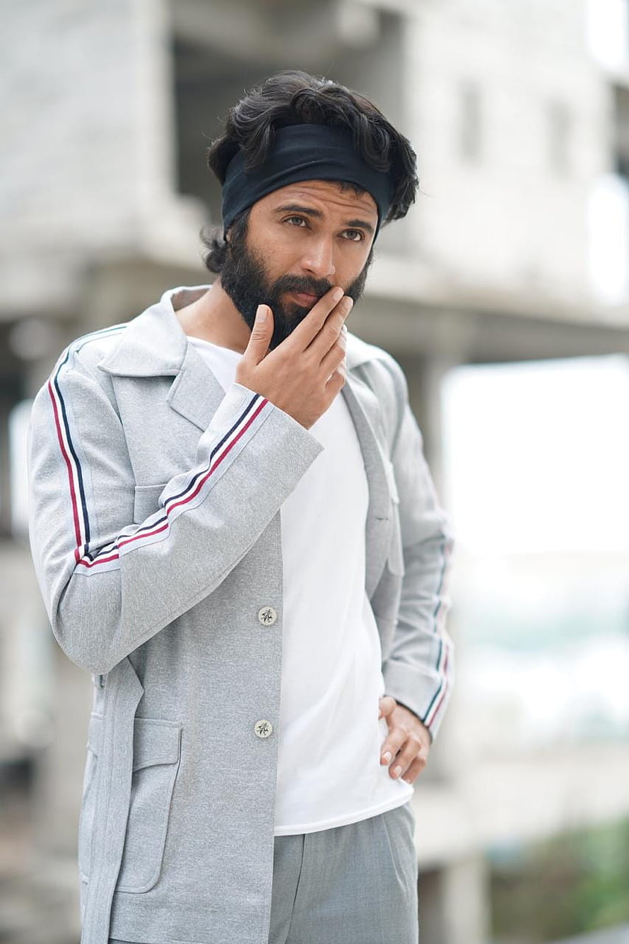 Vijay Devarakonda in a grey track jacket and black headband posing outdoors HD phone wallpaper