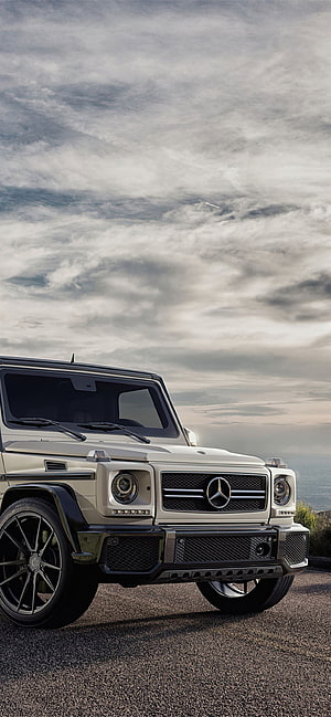 Mercedes-Benz G-Class SUV in Silver Parked on Coastal Road Under Cloudy Sky HD phone wallpaper