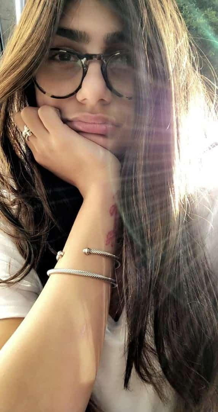 Portrait of a woman with long brown hair wearing glasses and silver bracelets, Mia Khalifa HD phone wallpaper
