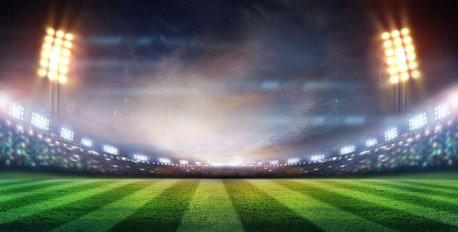 Empty Football Stadium at Night with Bright Floodlights and Green Grass Field HD wallpaper