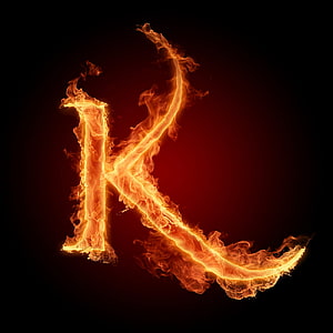 Burning Letter K in Vivid Orange Flames Against a Dark Background HD phone wallpaper