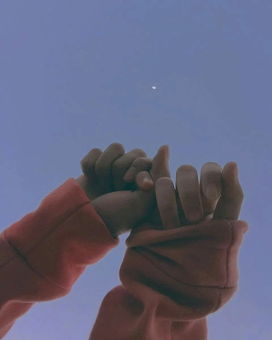 Interlocked Hands Against a Soft Blue Sky with a Distant Moon HD phone wallpaper