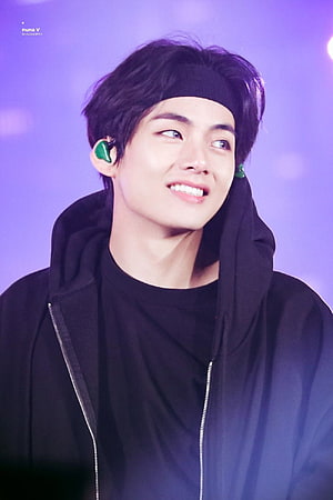 V from BTS smiling in black hoodie and headband on purple stage HD phone wallpaper