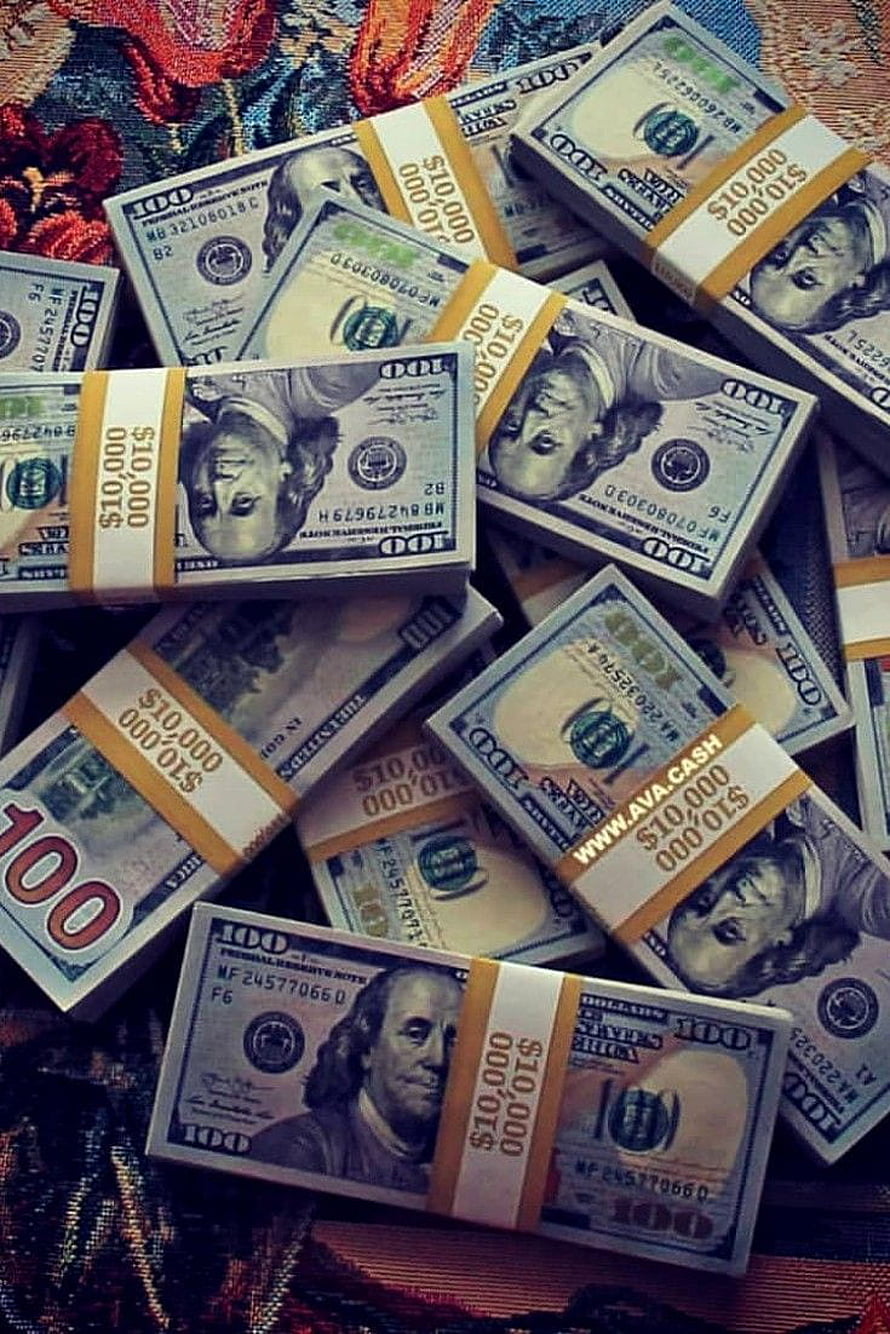 Stacks of bundled hundred dollar bills scattered on a colorful patterned fabric background HD phone wallpaper