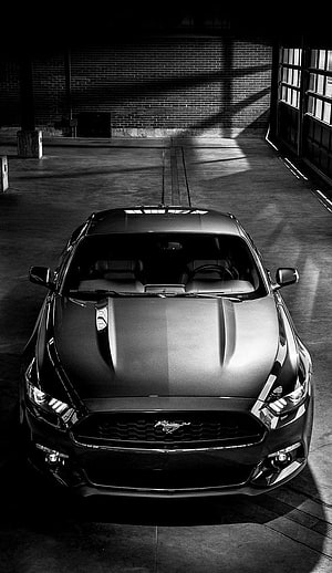 Black Ford Mustang GT Front View in Industrial Garage Setting HD phone wallpaper
