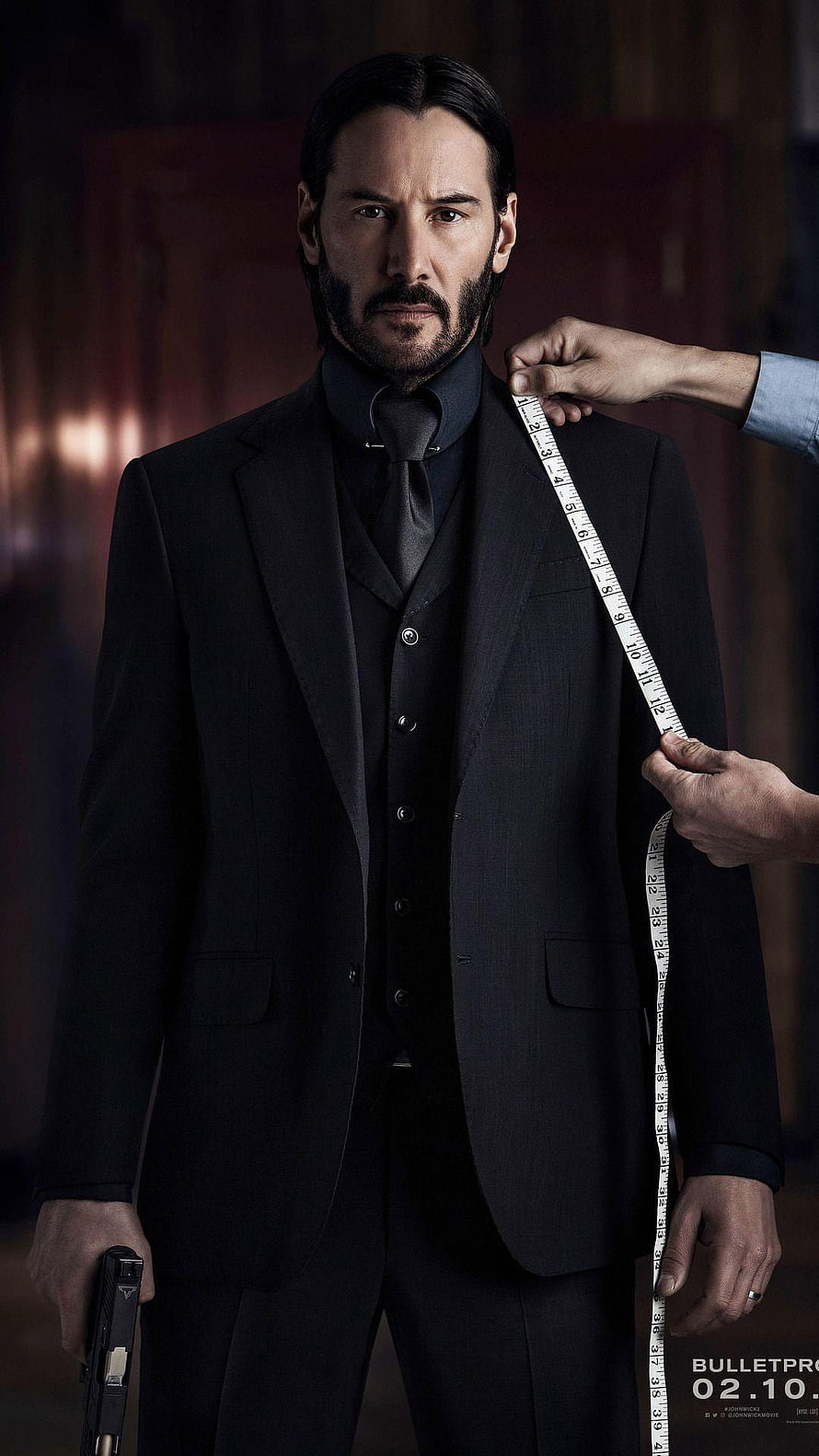 Keanu Reeves as John Wick in a black suit holding a gun while being measured for a tailor fit HD phone wallpaper