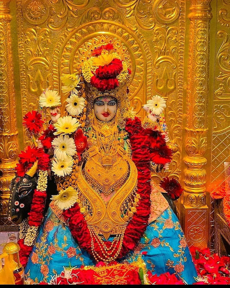 Goddess Kali adorned in gold jewelry and red flowers against an ornate golden temple background HD phone wallpaper