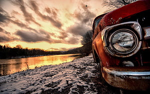 Vintage Red Rusty Car Parked by Snowy River at Sunset HD wallpaper