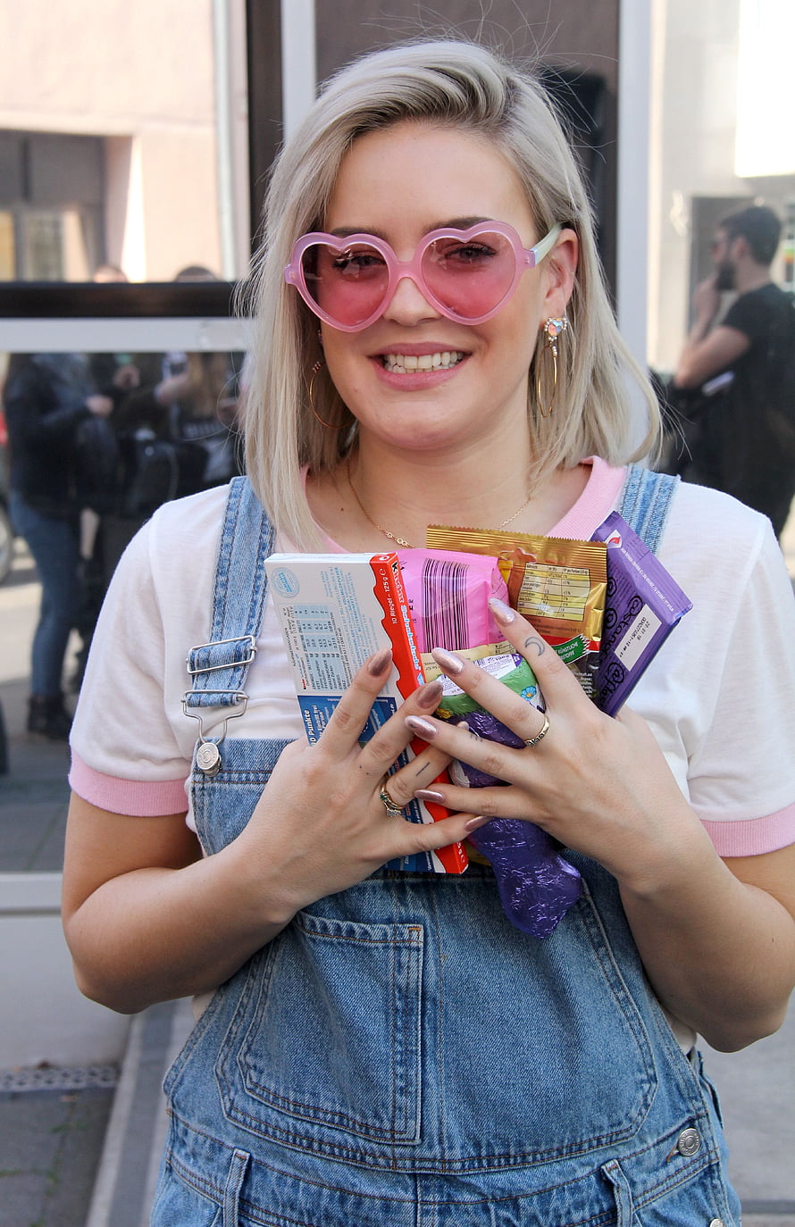 Anne Marie in Heart-Shaped Pink Sunglasses and Denim Overalls Holding Candy Bars HD phone wallpaper