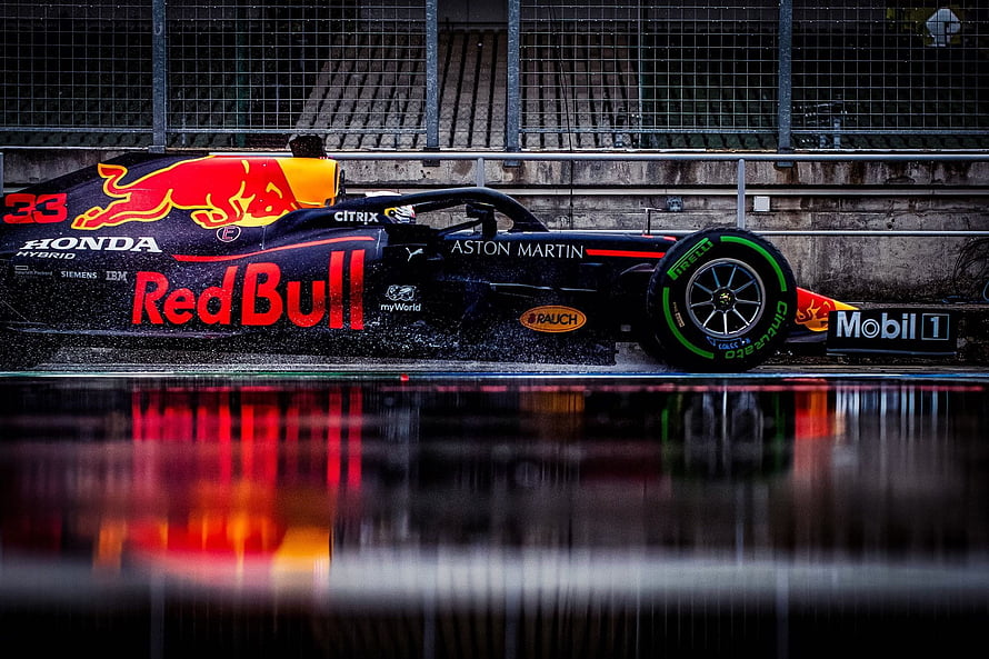 Red Bull Racing Formula 1 car with Max Verstappen on a wet track HD wallpaper