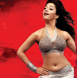 Tamanna Bhatia in Sparkling Silver Dance Costume Against Vibrant Red Background HD phone wallpaper