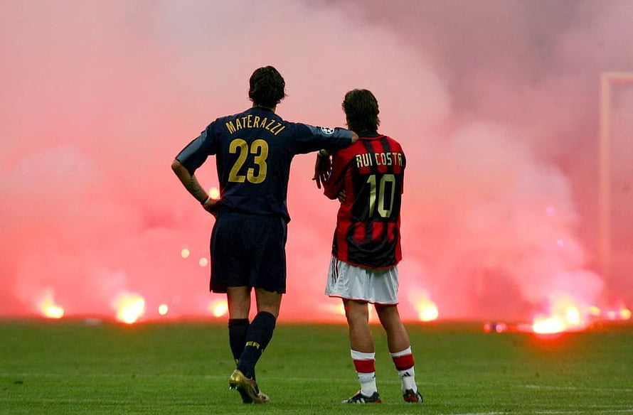 Materazzi and Rui Costa standing on soccer pitch with red flares in background HD wallpaper