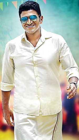 Puneeth Rajkumar in a cream kurta and sunglasses at a festive event HD phone wallpaper