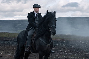 Peaky Blinders Tommy Shelby Riding a Black Horse in a Misty Landscape HD wallpaper