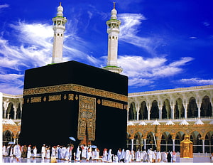 The Kaaba in Mecca with pilgrims performing Tawaf under a blue sky HD wallpaper