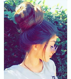 Young woman with a high messy bun hairstyle and sunglasses in profile against a leafy green hedge, Stylish Girl , s Of, instagram dp HD phone wallpaper
