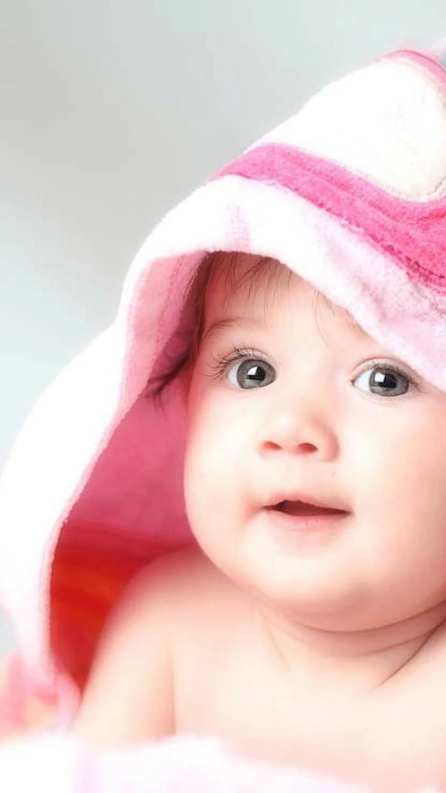 Adorable baby wrapped in a pink hooded towel with big curious eyes HD phone wallpaper