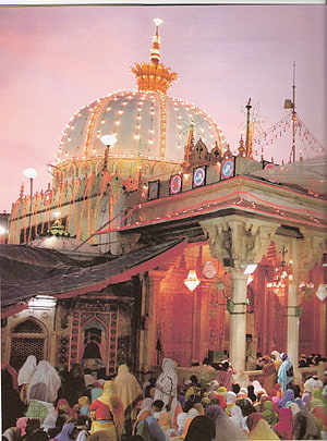Ajmer Sharif Dargah illuminated at dusk with a large crowd of pilgrims gathered in the courtyard HD phone wallpaper