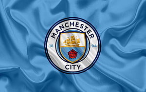 Manchester City Football Club Crest on Flowing Sky Blue Silk Fabric Background HD wallpaper