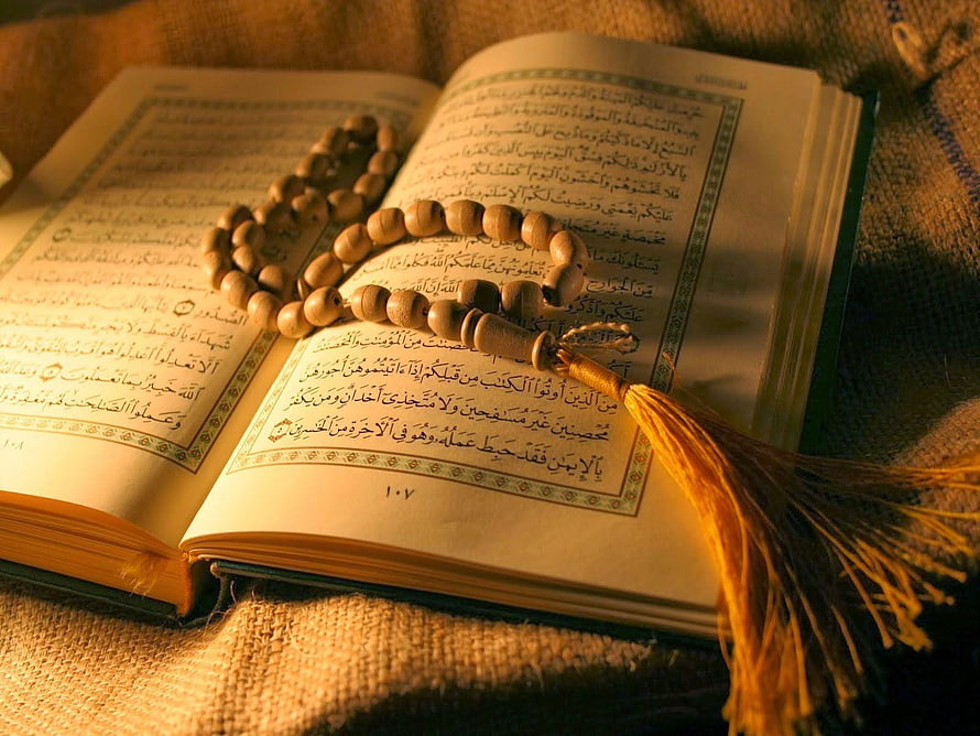 Open Quran with wooden tasbih prayer beads on rustic fabric background HD wallpaper