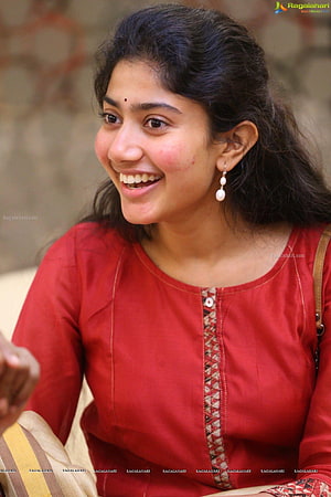 Sai Pallavi smiling portrait wearing a red kurta with traditional embroidery and pearl earrings HD phone wallpaper