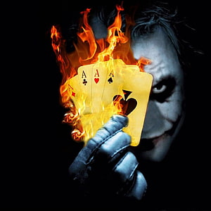 The Joker holding four aces engulfed in flames against a dark background HD phone wallpaper