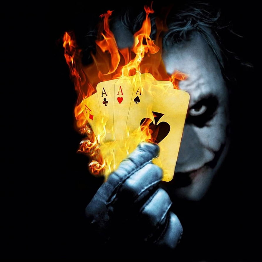 The Joker holding four aces engulfed in flames against a dark background HD phone wallpaper