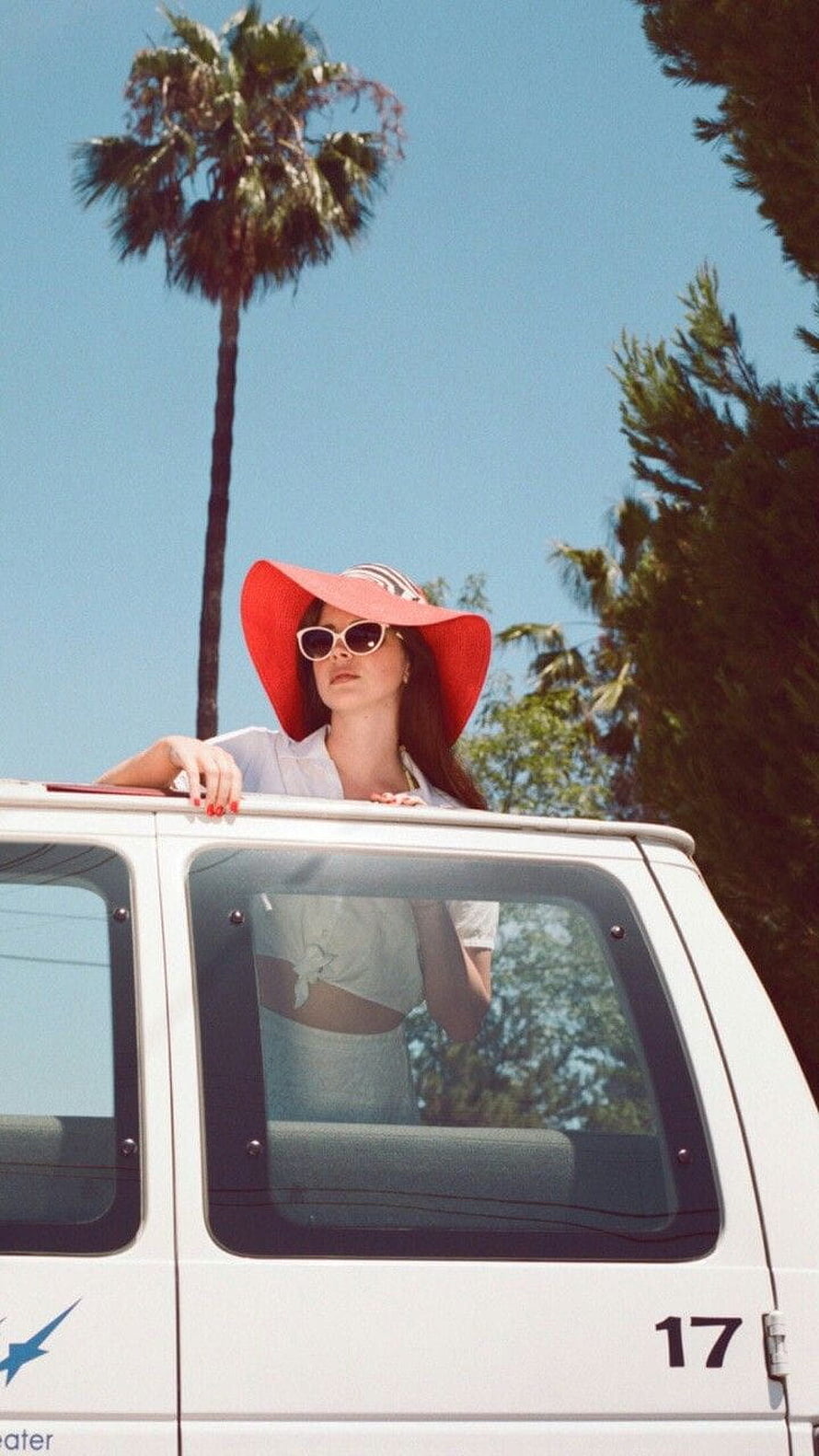 Lana Del Rey in a red sun hat leaning from a white van under a palm tree HD phone wallpaper