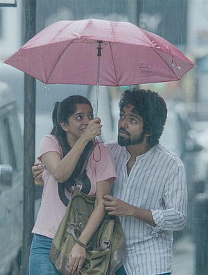 Romantic couple sharing a pink umbrella in the rain, cinematic still from the movie Thani Oruvan, GV Prakash Bachelor Movie Stills, Gallery, bachelor tamil HD phone wallpaper