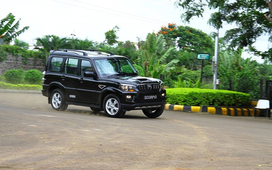 Black Mahindra Scorpio SUV Driving on a Road with Lush Greenery HD wallpaper