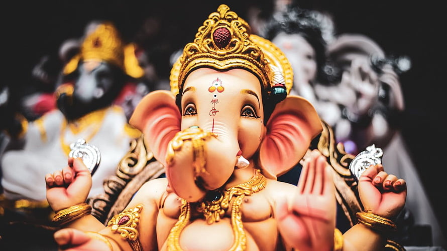 Lord Ganesha Murti with Golden Crown and Ornate Jewelry in Temple Setting HD wallpaper