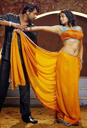Pawan Kalyan and Pooja Hegde in vibrant yellow saree dance scene from Indian movie HD phone wallpaper