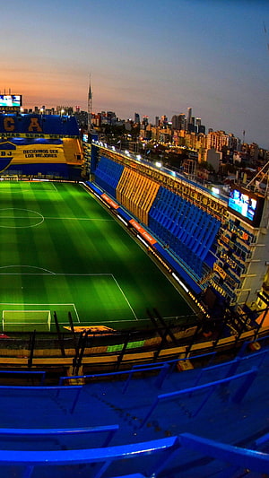 Boca Juniors Stadium at Dusk with City Skyline and Floodlit Pitch HD phone wallpaper