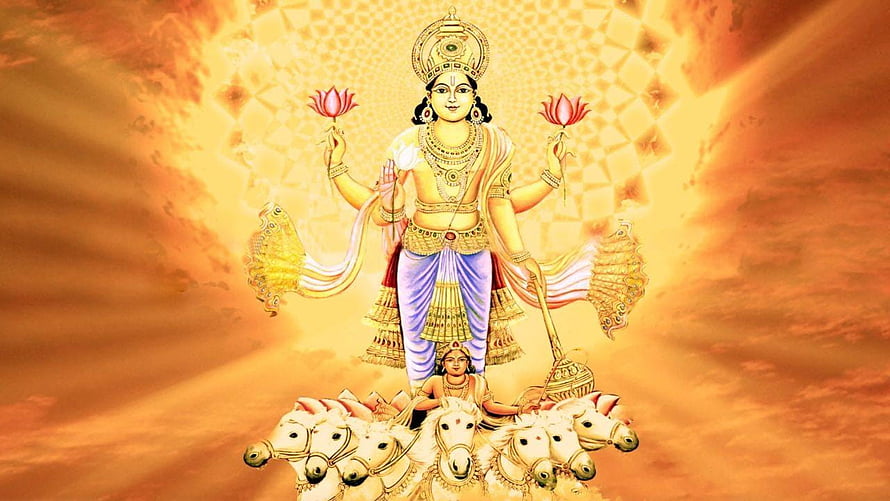 Lord Surya Dev riding a seven-horse chariot with lotus flowers and radiant golden aura HD wallpaper