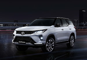 Silver Toyota Fortuner Legender SUV Parked on Wet City Street at Night HD wallpaper