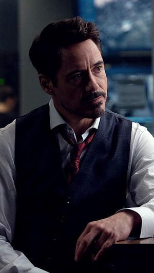 Robert Downey Jr as Tony Stark in a dark vest and red tie with a serious expression HD phone wallpaper