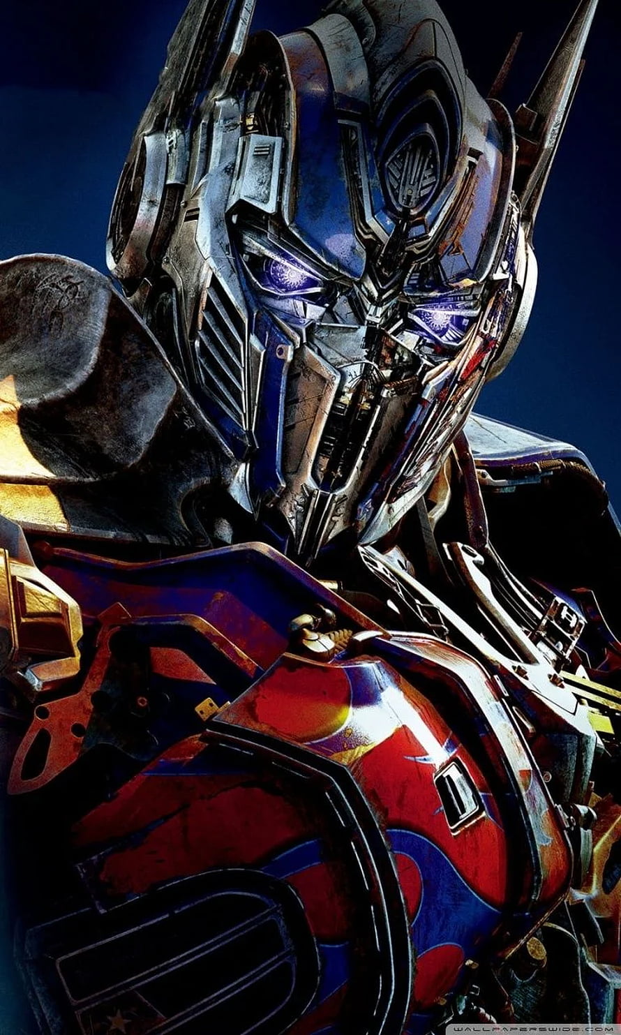 Transformers Optimus Prime Close-Up Portrait with Glowing Blue Eyes and Weathered Armor HD phone wallpaper