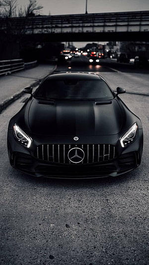Matte Black Mercedes-AMG GT S Front View on Urban Highway at Dusk HD phone wallpaper